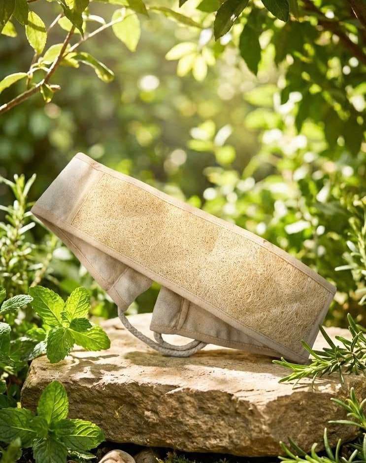 Loofah back scrubber belt resting on a stone among garden greenery
